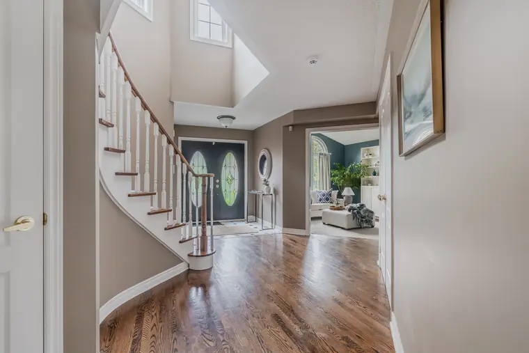 Foyer with curved staircase and hardwood floors